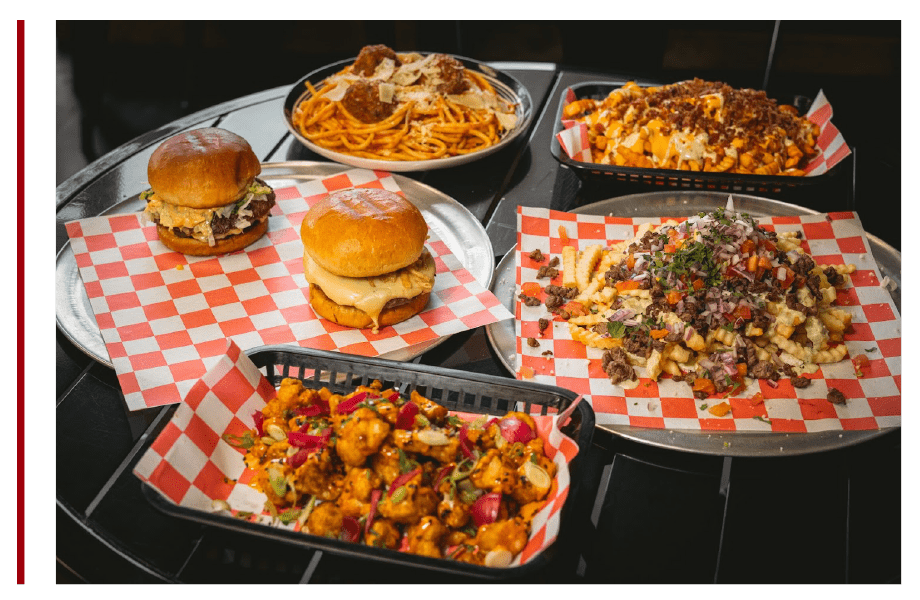 A table topped with plates of food and hamburger.